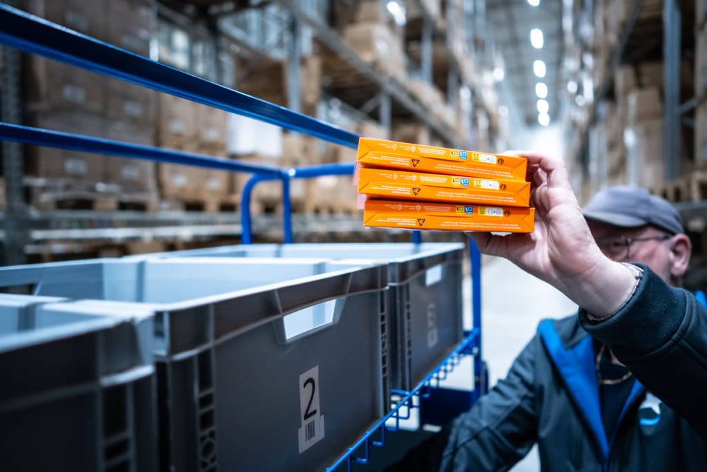 Un homme trie des produits à l'intérieur d'un entrepôt