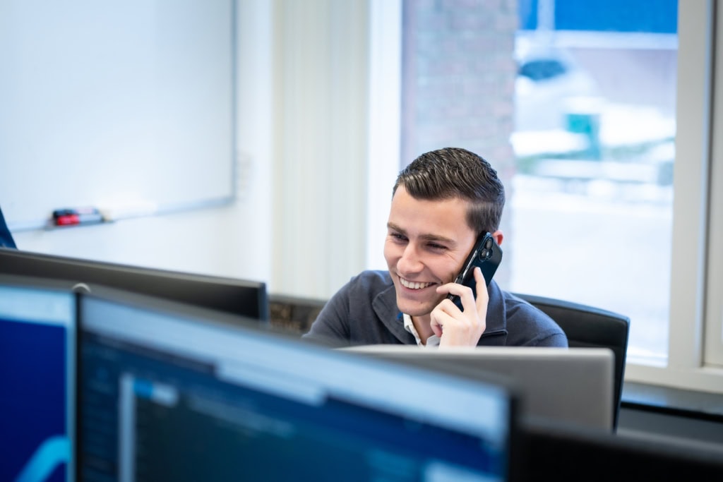 Un homme appelle derrière un bureau