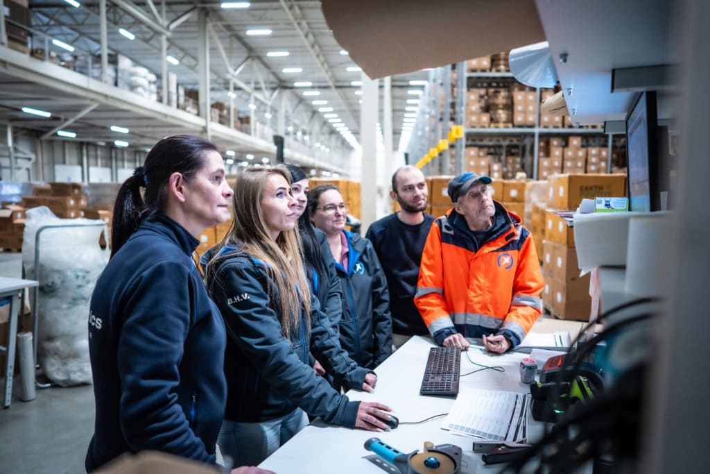 Team looking at screen inside warehouse