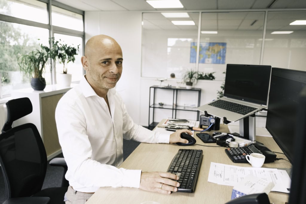 Man sitting at a desk in front of computer screens